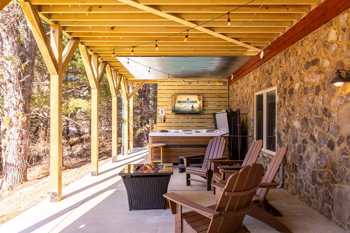An outdoor social space featuring a bubbling hot tub, comfortable seating, and a modern fire pit. The area is decorated for comfort and fun, perfect for evening conversations, making s'mores, or soaking under the stars.